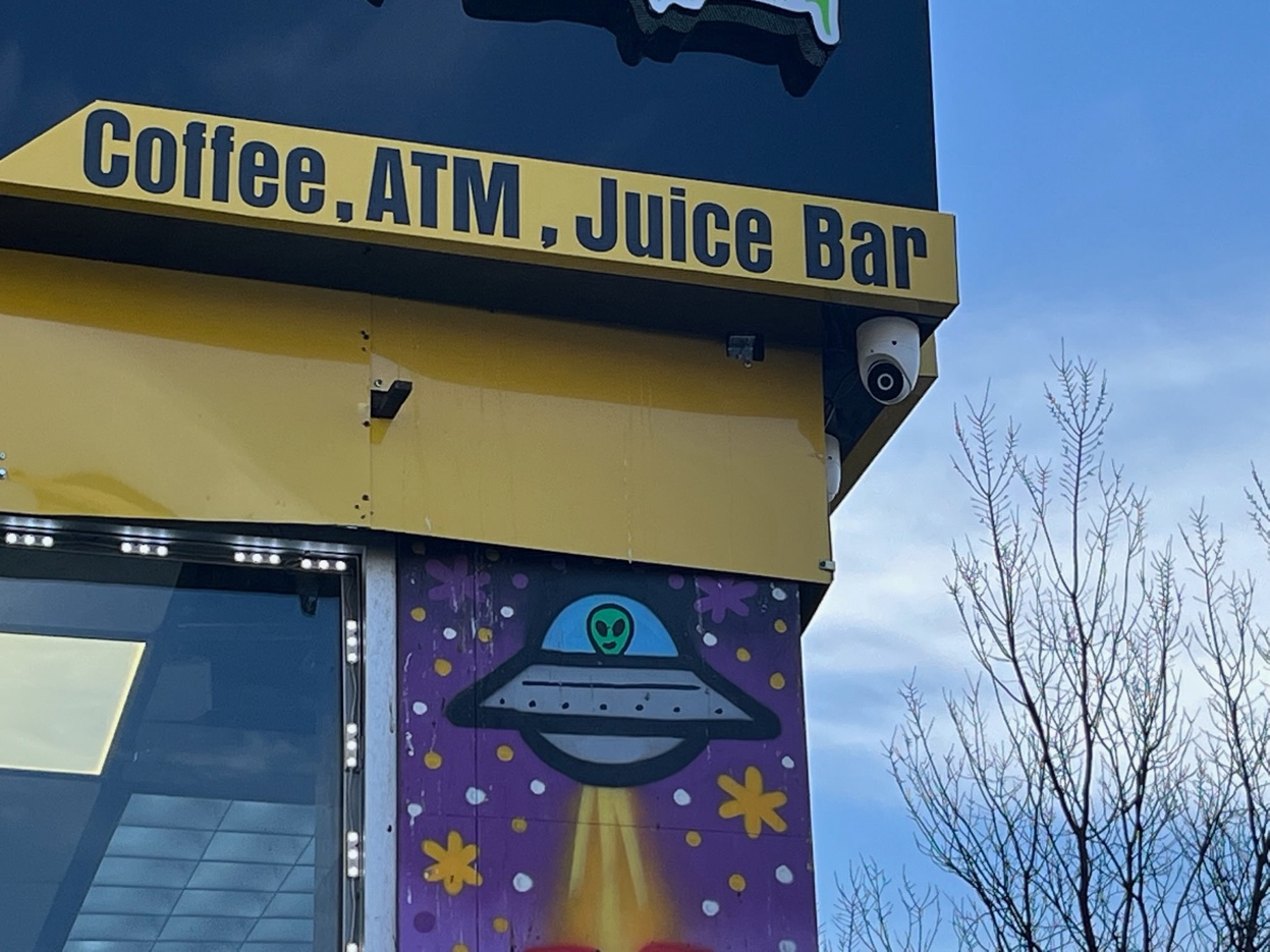 Exterior dome security camera mounted on deli storefront Washington Heights Manhattan NY